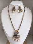 Oxidised dual-tone Ganesha long necklace set displayed on a white jewellery bust with matching pearl-drop earrings