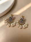 Pair of dual-tone Ganesha chandbali earrings with multicolour stones and faux pearl drops on a beige surface
