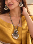 Model wearing oxidised Ganesha long necklace and matching earrings styled with a gold silk saree