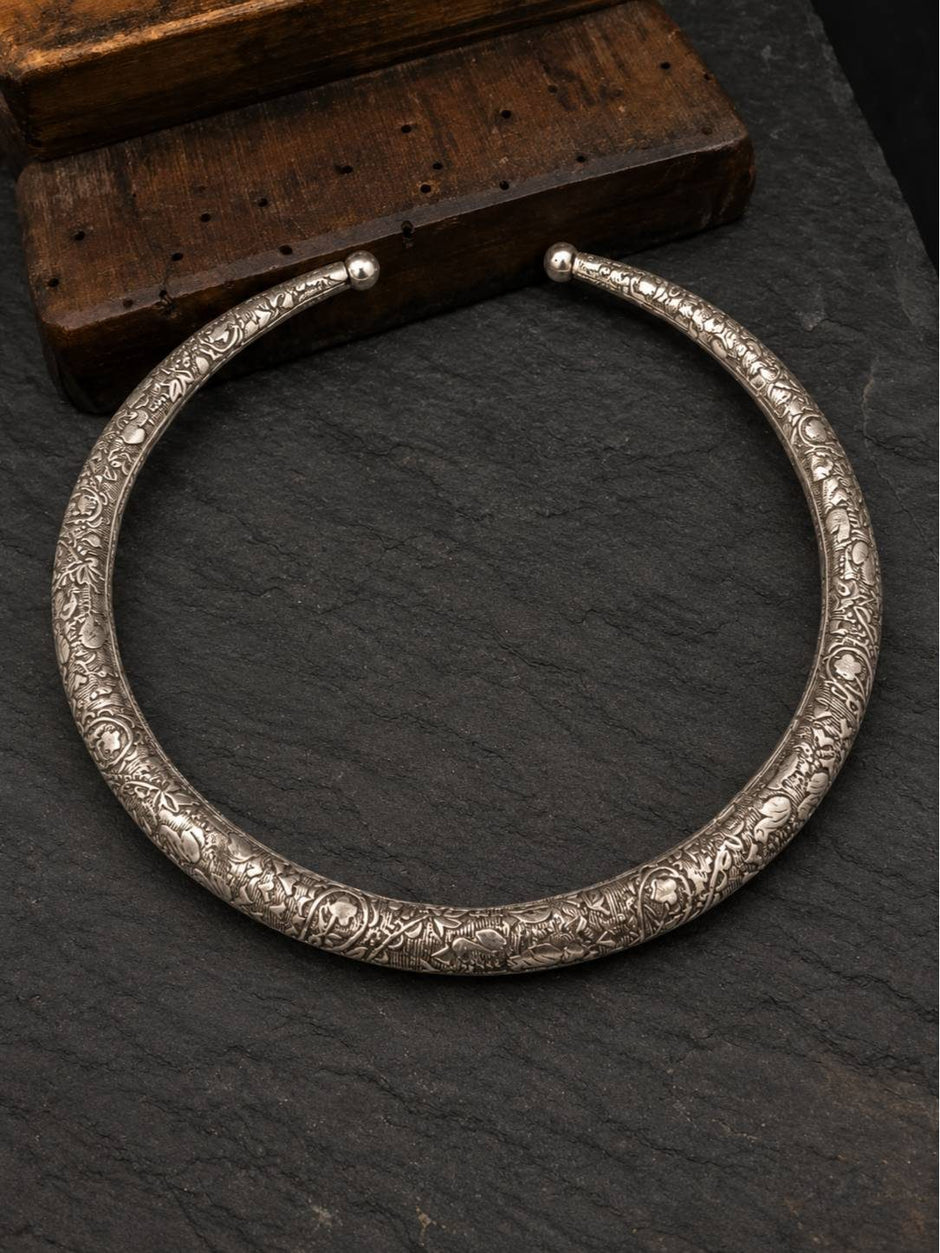 Full circular view of oxidised silver torque choker with ball terminals on dark slate surface