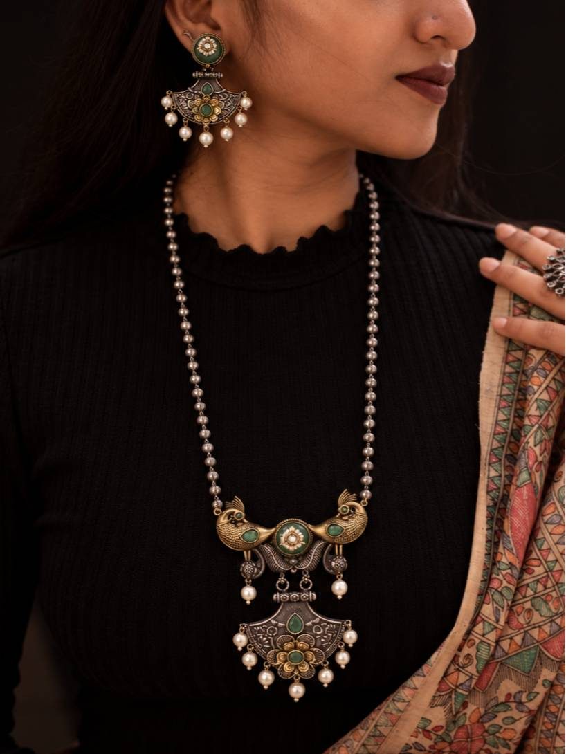 Model wearing oxidised peacock necklace and earrings with black top and printed dupatta