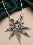 Close-up of oxidised silver cannabis leaf pendant with textured detailing and polished ball bead accents on snake chain
