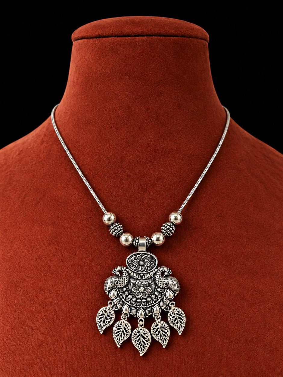 Oxidised silver pendant necklace displayed on a burgundy velvet jewellery bust