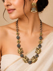 Woman wearing oxidised elephant necklace and jhumka earrings with a cream silk saree