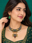 Woman wearing oxidised hasli necklace set with green embroidered lehenga and matching drop earrings