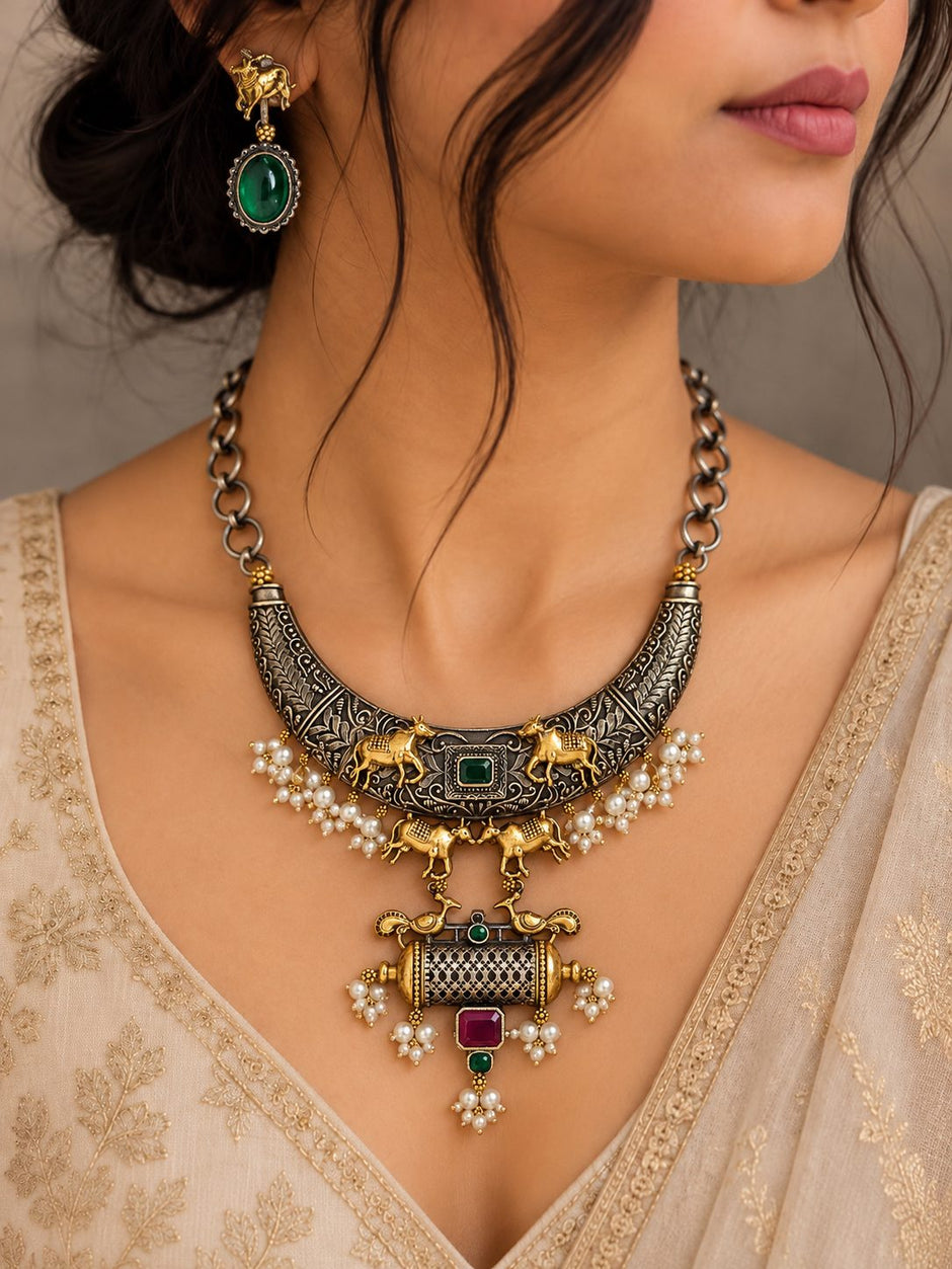 Close-up of oxidised dual tone necklace with filigree pendant on woman in ivory embroidered outfit
