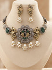 Oxidised dual-tone peacock choker necklace and earring set displayed on a cream jewellery bust