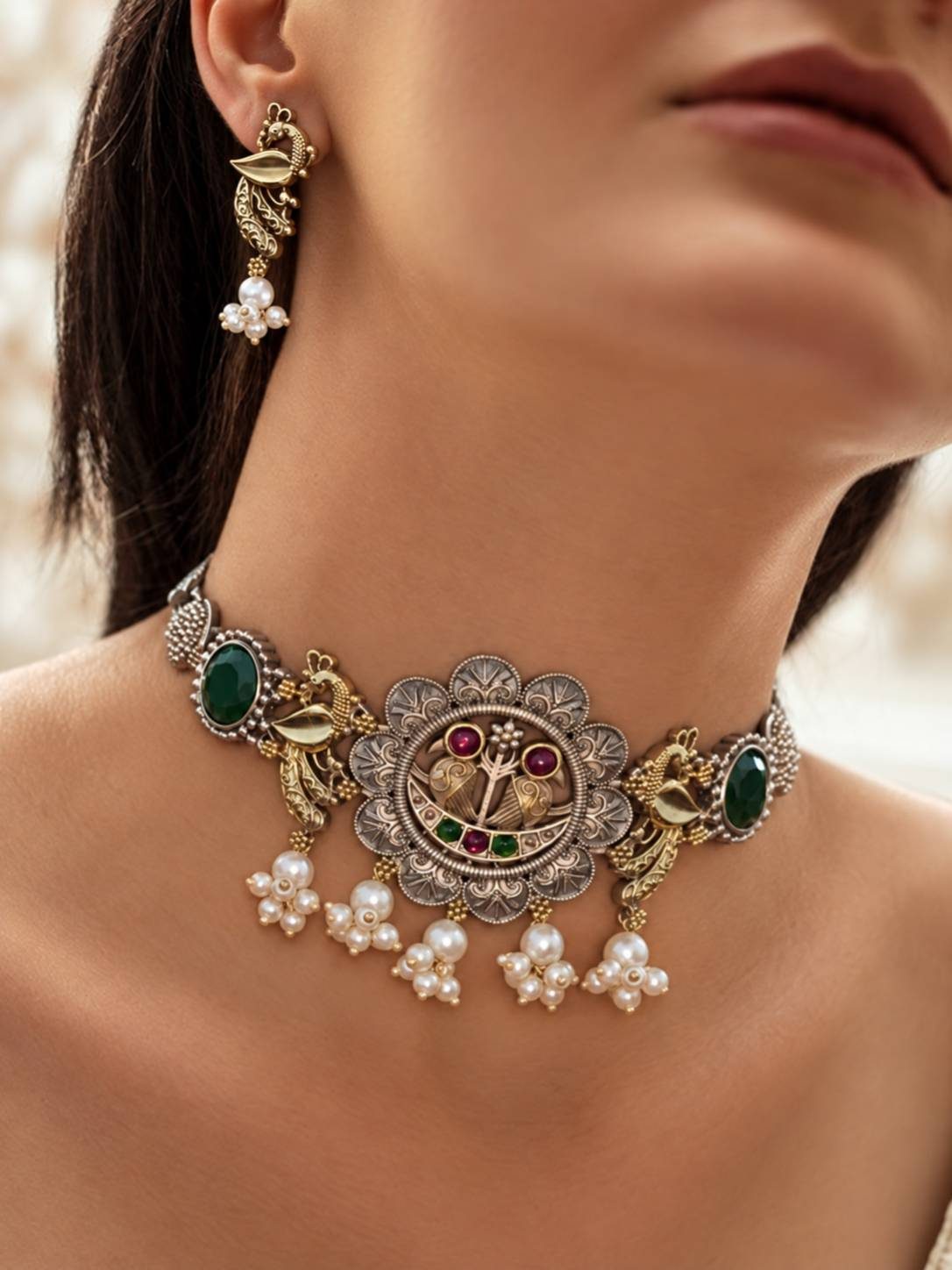 Woman wearing oxidised peacock choker with green stones and pearl drops around her neck