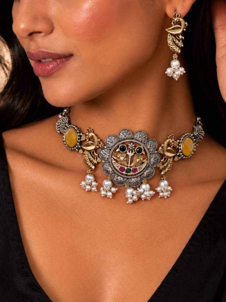 Model wearing oxidised peacock choker at collarbone with matching gold-tone peacock earrings