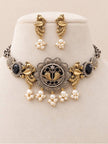 Oxidised dual-tone peacock choker necklace and drop earrings displayed on a cream velvet jewellery stand