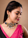 Woman wearing oxidised peacock choker with blue stones and pearl drops over a pink and black saree blouse