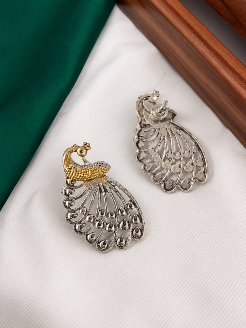Front and back view of dual-tone peacock stud earrings showing gold head and silver filigree tail detail