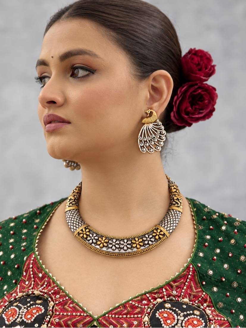 Woman wearing dual-tone oxidised choker necklace and peacock earrings with an embroidered green and red outfit