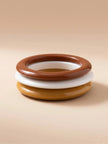 Front-facing view of three resin bangles stacked flat showing terracotta on top, ivory in middle and mustard at the base