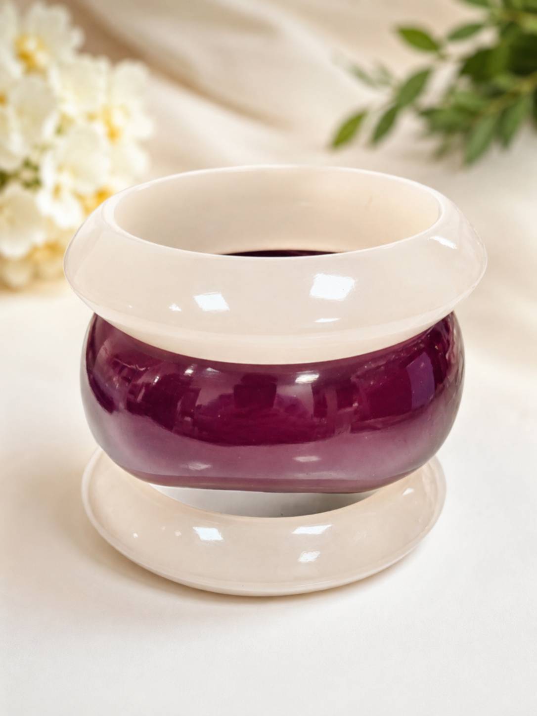 Three resin bangles stacked vertically on a display stand, showing white and deep burgundy glossy finish