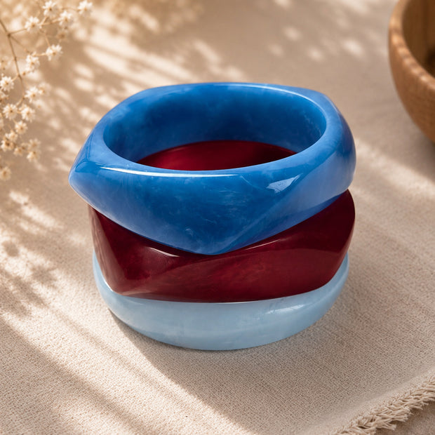 Three marble resin bangles stacked on top of each other showing the faceted angular shape from above