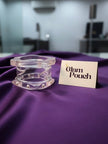 Clear acrylic bangles with faux pearl detail displayed on purple silk beside a Glam Pouch brand card