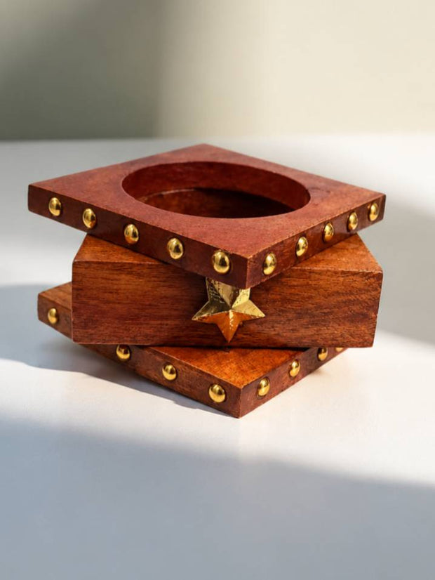Three wooden square bangles stacked together showing brass dome studs and gold star accent
