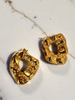 Two gold-plated molten texture open studs laid flat on a white marble background
