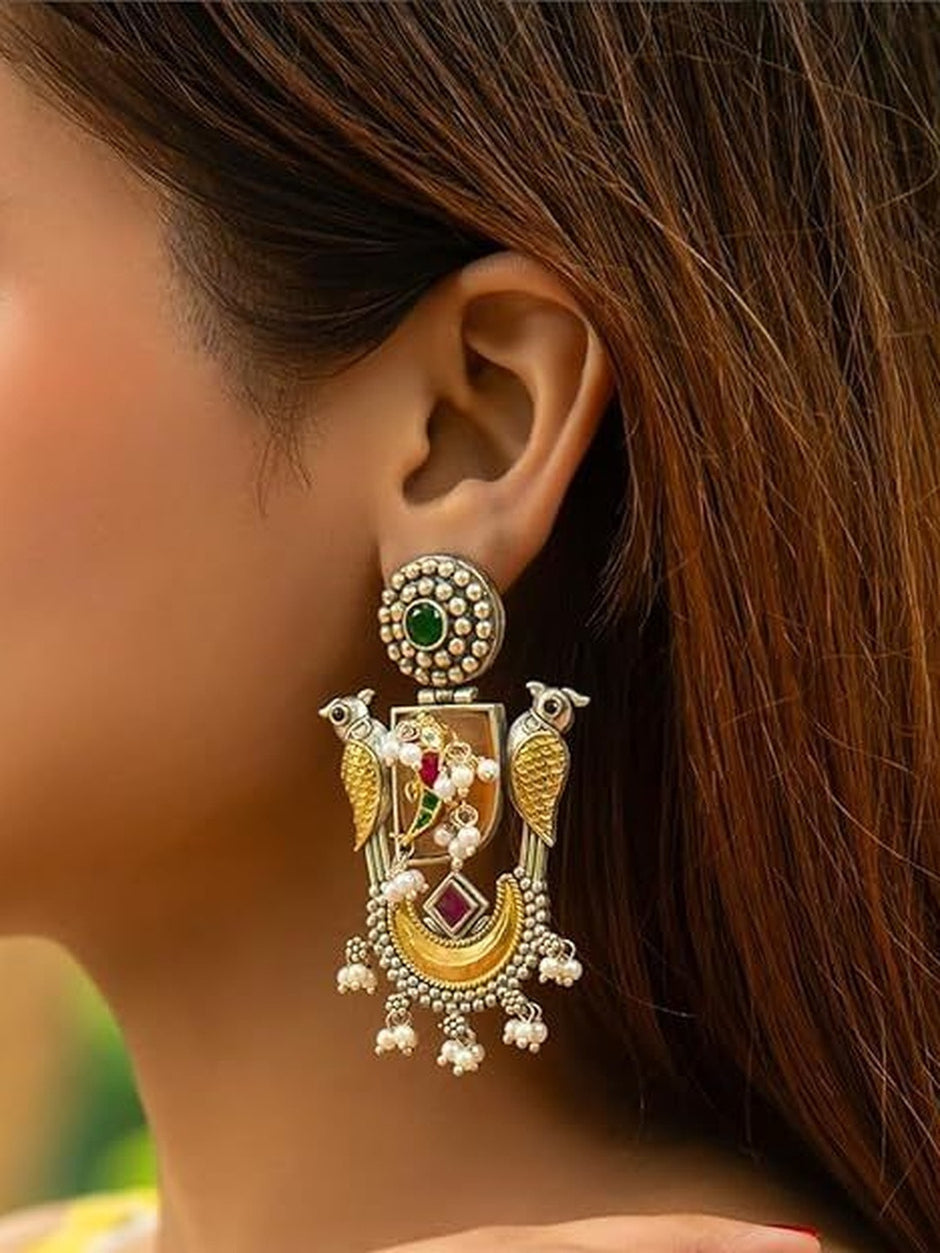 Oxidised dual-tone parrot chandbali earring worn on a woman's ear showing full drop detail