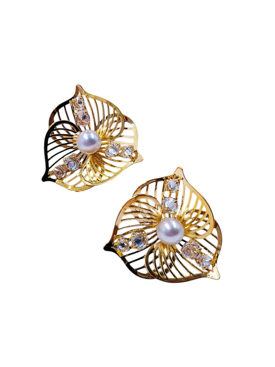 Front view of gold-plated pearl and crystal leaf stud earrings displayed as a matching pair on white background