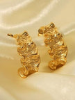 Close-up of gold ruffled hoop earrings on white background with slight shadow highlighting 3D form