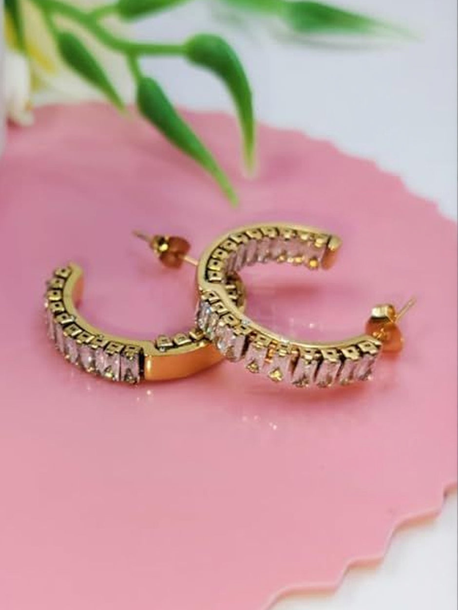 Close-up of gold-plated baguette cubic zirconia hoop earrings showing push-back stud fastening