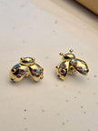 Pair of gold-plated ladybug stud earrings with ruby-red zirconia on a white speckled surface