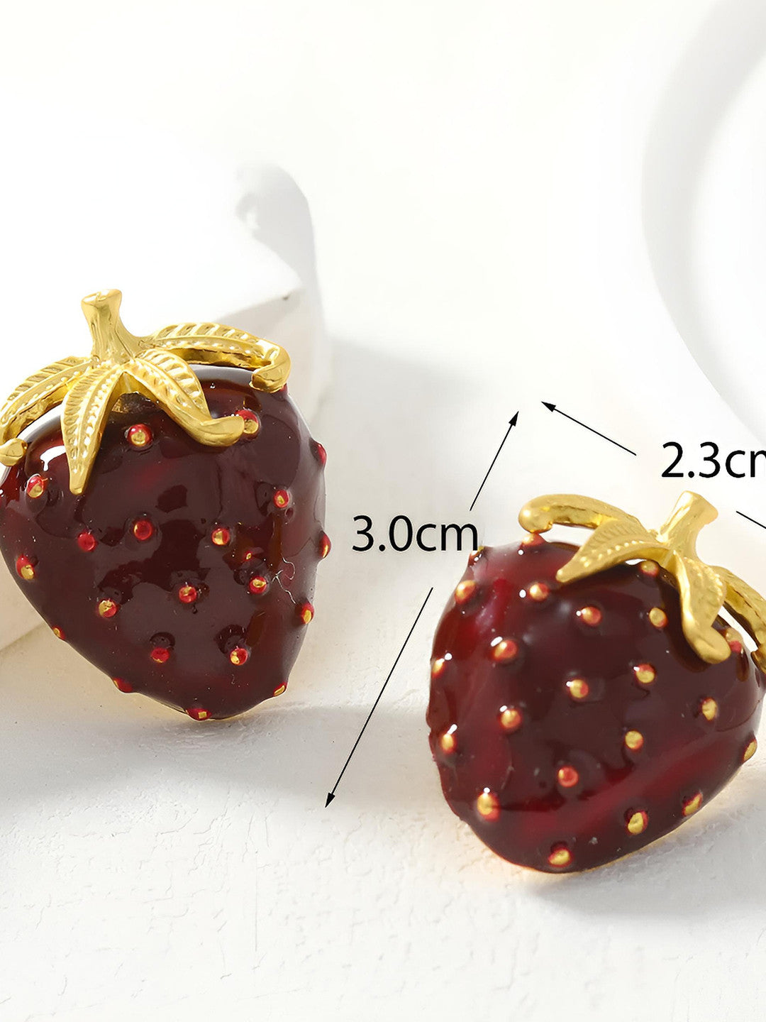 Two red enamel strawberry earrings with dimension arrows showing 3.0 cm height and 2.3 cm width