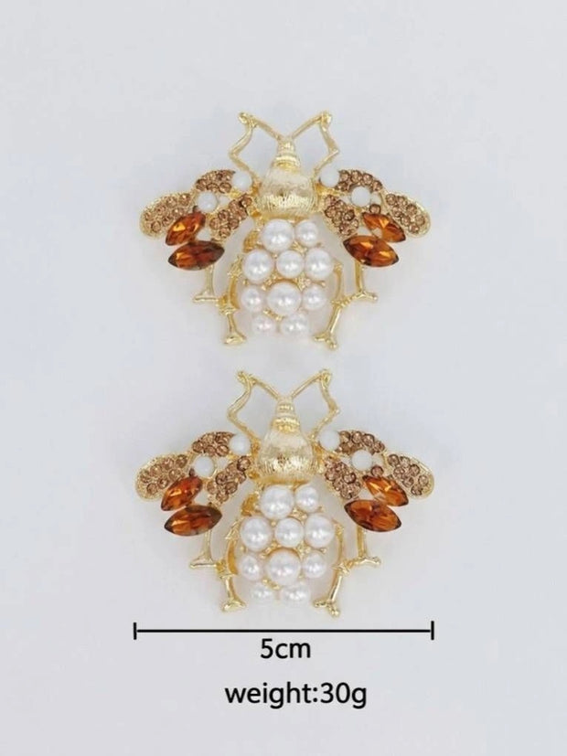 Flat lay of a pair of bee stud earrings with size reference showing approximately 5 cm width and 30 g weight