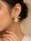 Gold honeybee pearl stud earring worn on woman's ear showing full silhouette with crystal wings and faux pearl body