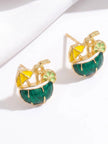 Pair of gold-plated coconut cocktail enamel stud earrings with green body, yellow umbrella and lime slice detail, displayed on white fabric