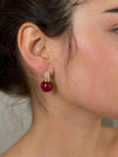 Gold-plated red ball baguette crystal stud earring worn on a model's ear showing side profile and fit