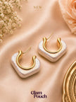 Pair of pearlescent white resin hoop earrings with gold-plated inner hoop on blush satin fabric with flowers
