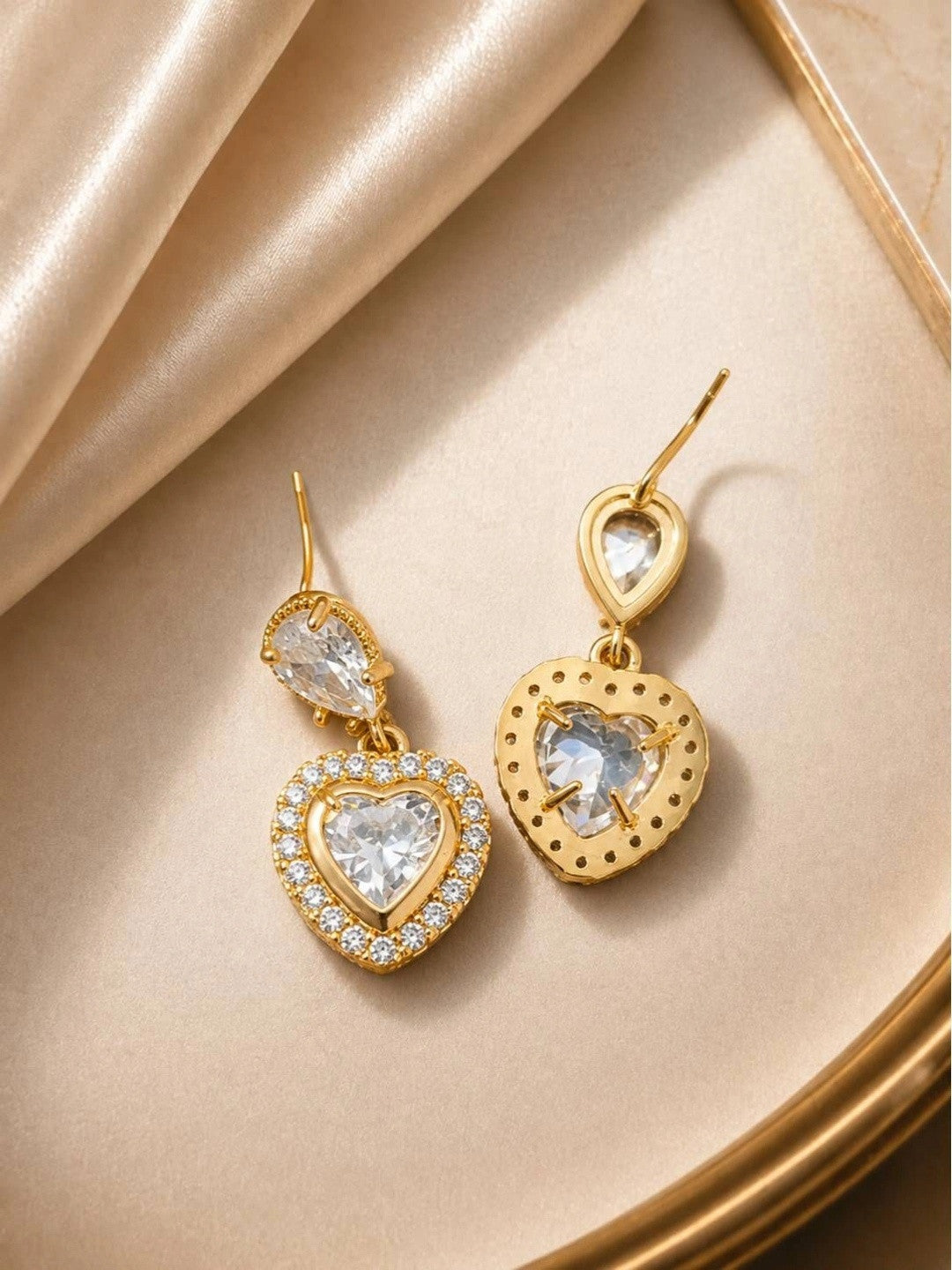 Front and back view of gold heart drop earrings showing pavé halo and plain reverse side