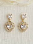 Pair of gold-plated heart CZ drop earrings displayed upright against a white textured background