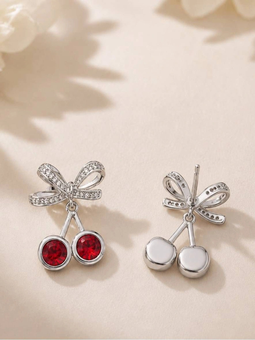 Front and back view of cherry bow earrings showing pavé bow and plain silver reverse of cherry charms