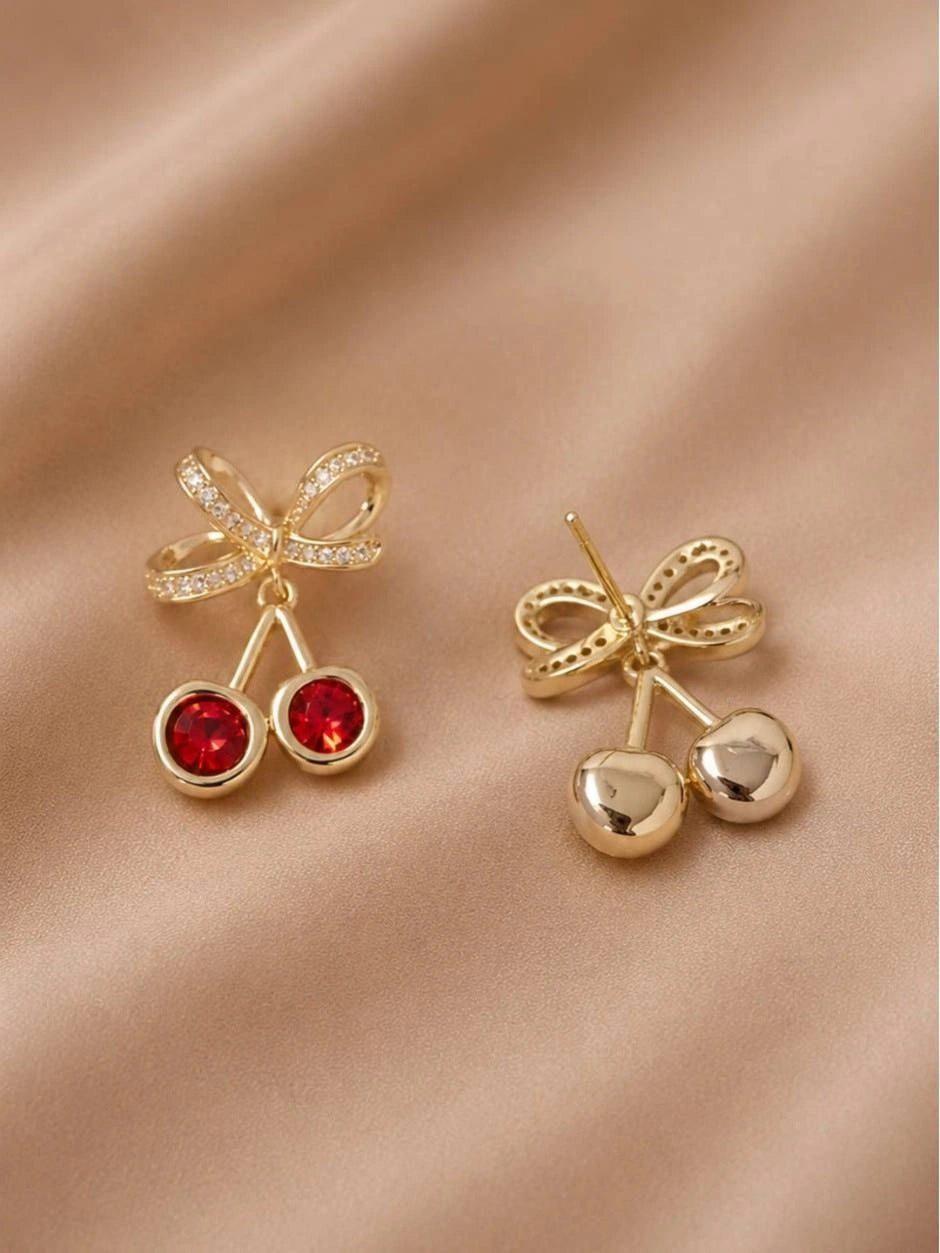 Front and back view of gold-plated cherry crystal drop stud earrings on a satin background