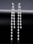 Pair of long silver CZ teardrop drop earrings displayed upright against dark fabric