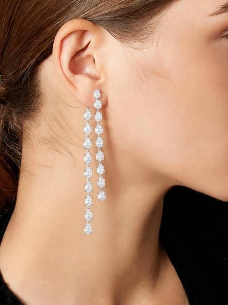Model wearing one long silver CZ teardrop earring shown from the side profile