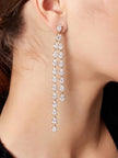 Gold-plated CZ teardrop drop earring worn on a model's ear showing full length against neck