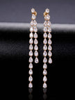 Front view of both gold-plated pear-cut CZ drop earrings standing upright on black satin surface