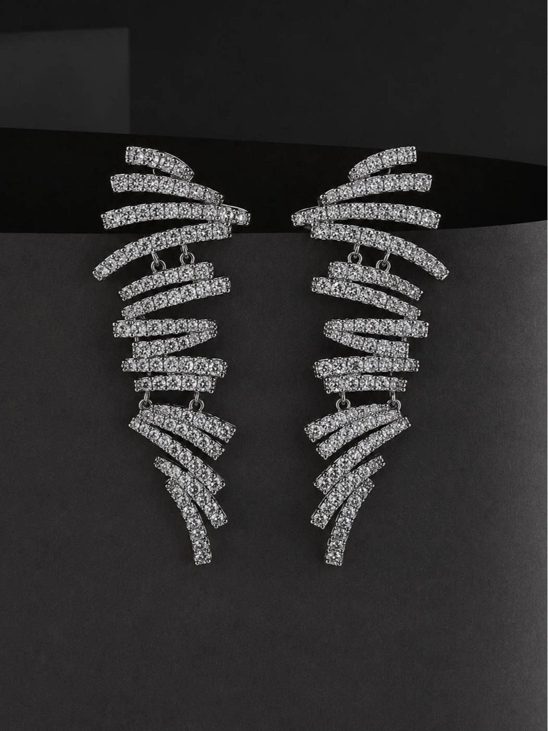 Both silver pave cubic zirconia spiral bar earrings displayed upright against a dark grey background