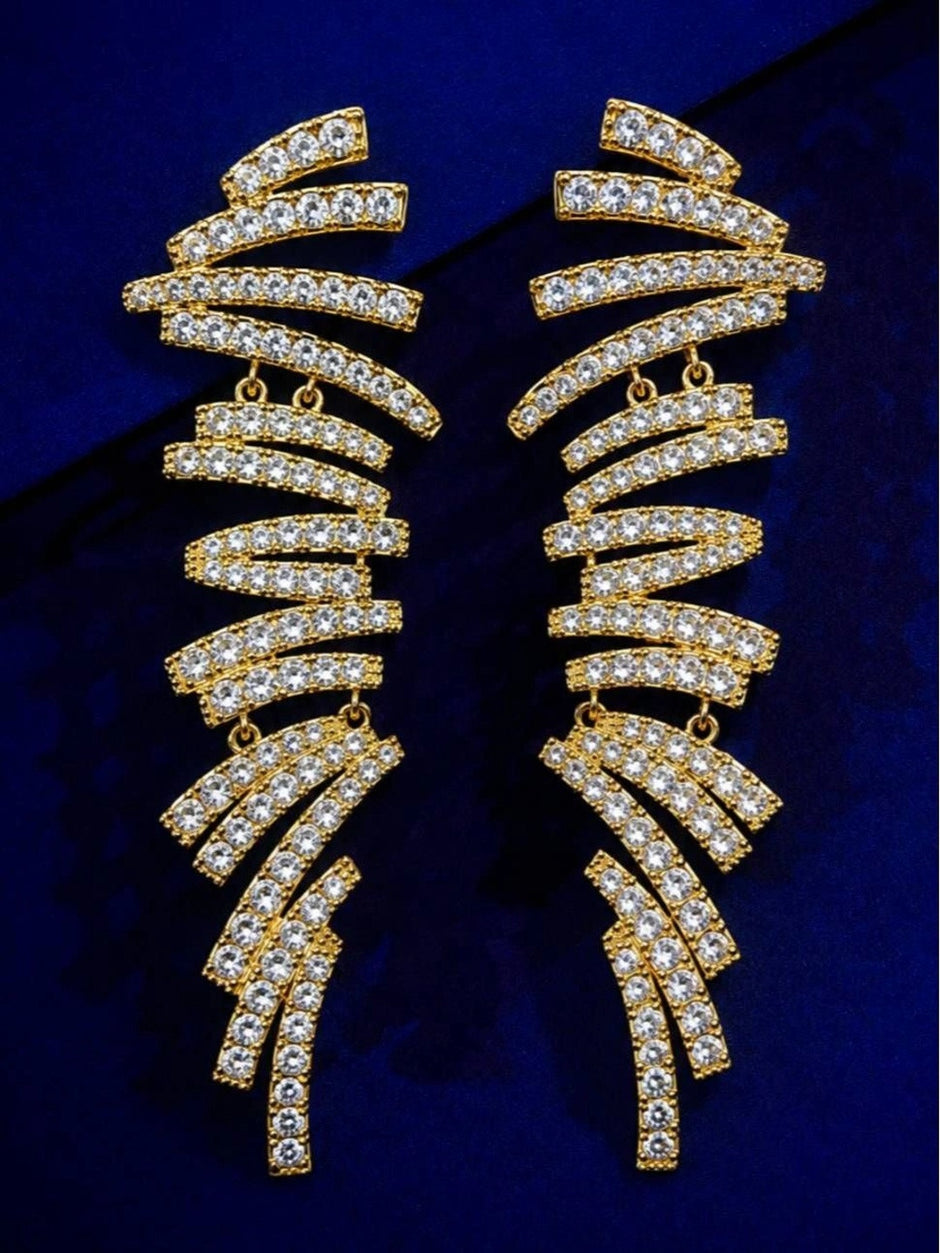 Pair of gold-plated crystal rhinestone bar drop earrings laid flat on royal blue velvet background