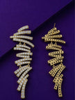 Front and back view of gold-plated zigzag bar drop earrings on purple surface showing stud post