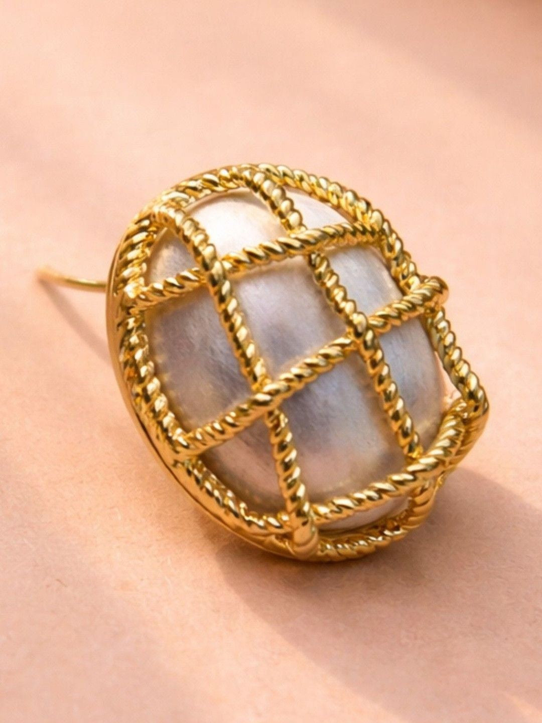 Single gold twisted rope cage stud earring showing brushed satin core detail up close