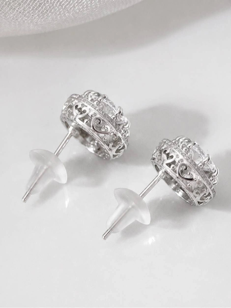 Back view of CZ halo stud earrings showing open filigree scrollwork band and butterfly push-back clasps
