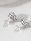 Back view of CZ halo stud earrings showing open filigree scrollwork band and butterfly push-back clasps