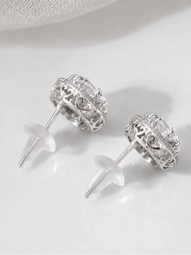 Back view of CZ halo stud earrings showing open filigree scrollwork band and butterfly push-back clasps