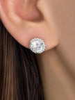 Silver-finish CZ halo stud earring worn on a woman's ear, showing size and sparkle against hair